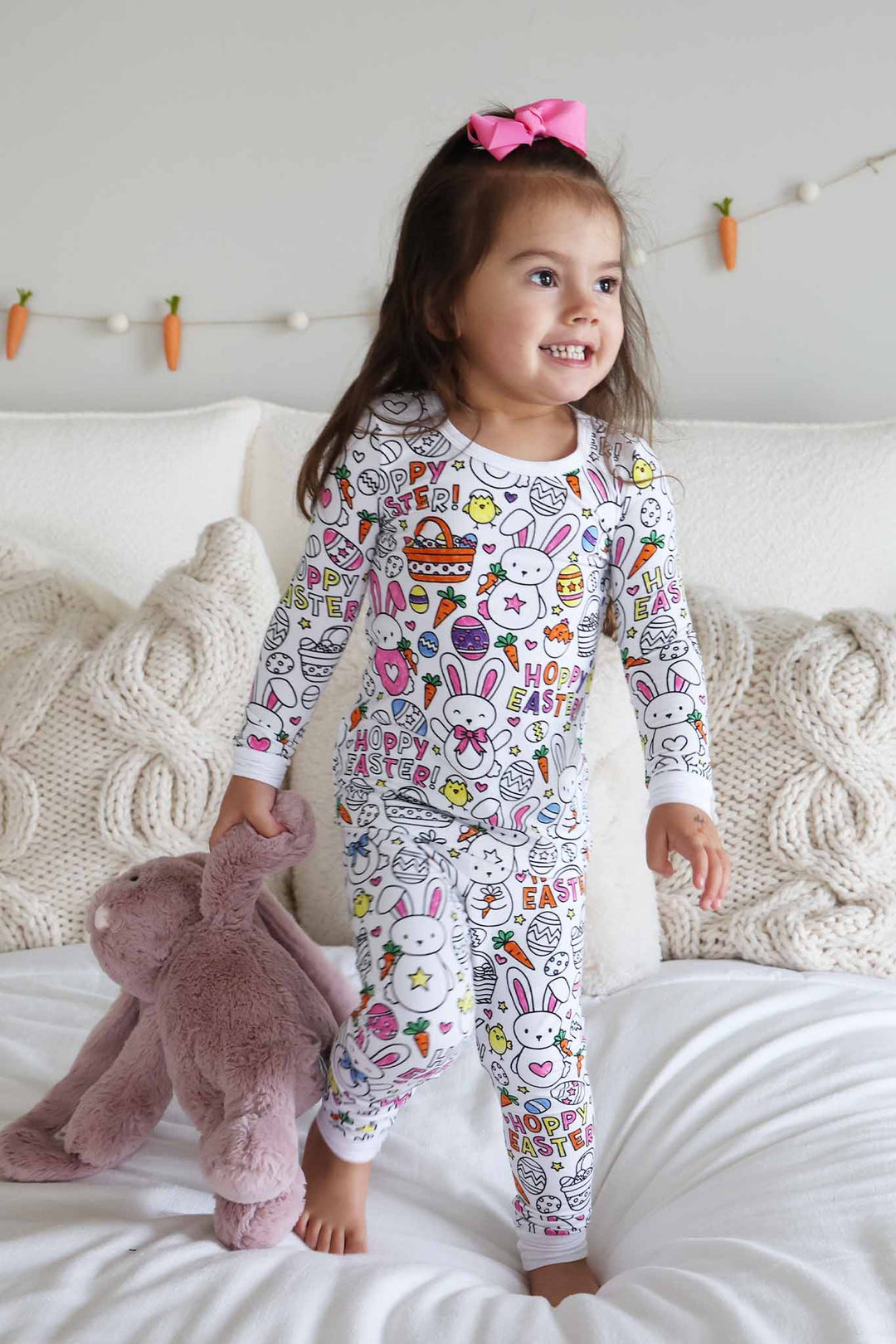 girl standing on bed wearing hoppy easter colorable two piece pajama set 