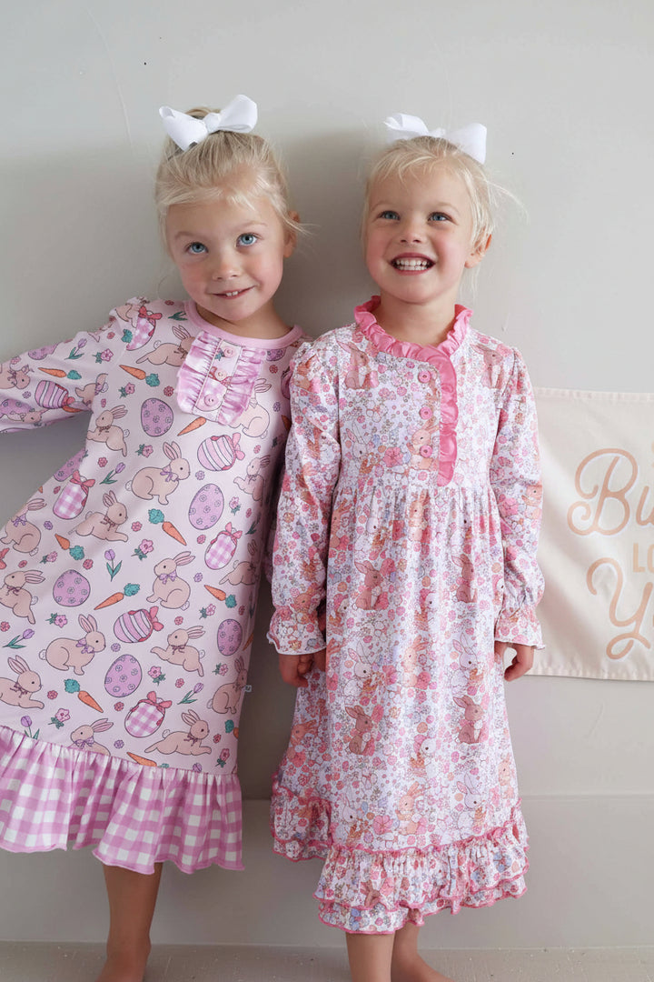 girls standing together in long sleeve easter nightgowns with a some bunny loves you sign in the back