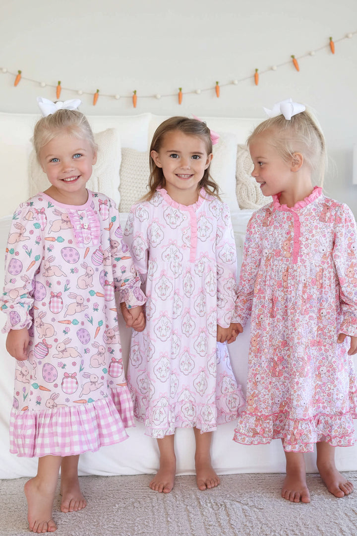 three girls holding hands wearing long sleeve easter nightgowns 
