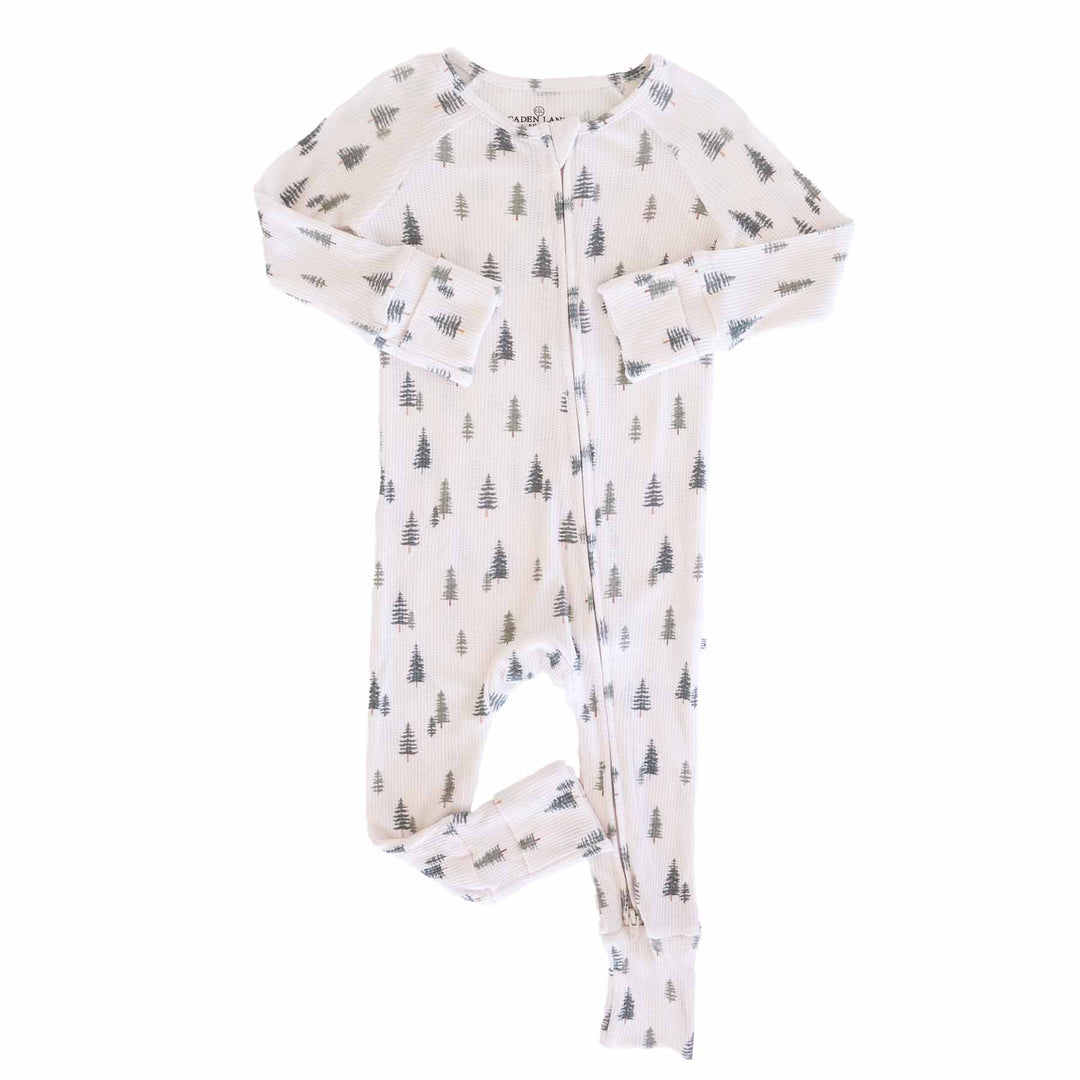 flat lay of evergreen controvertible zip romper. Green pine trees with white background 