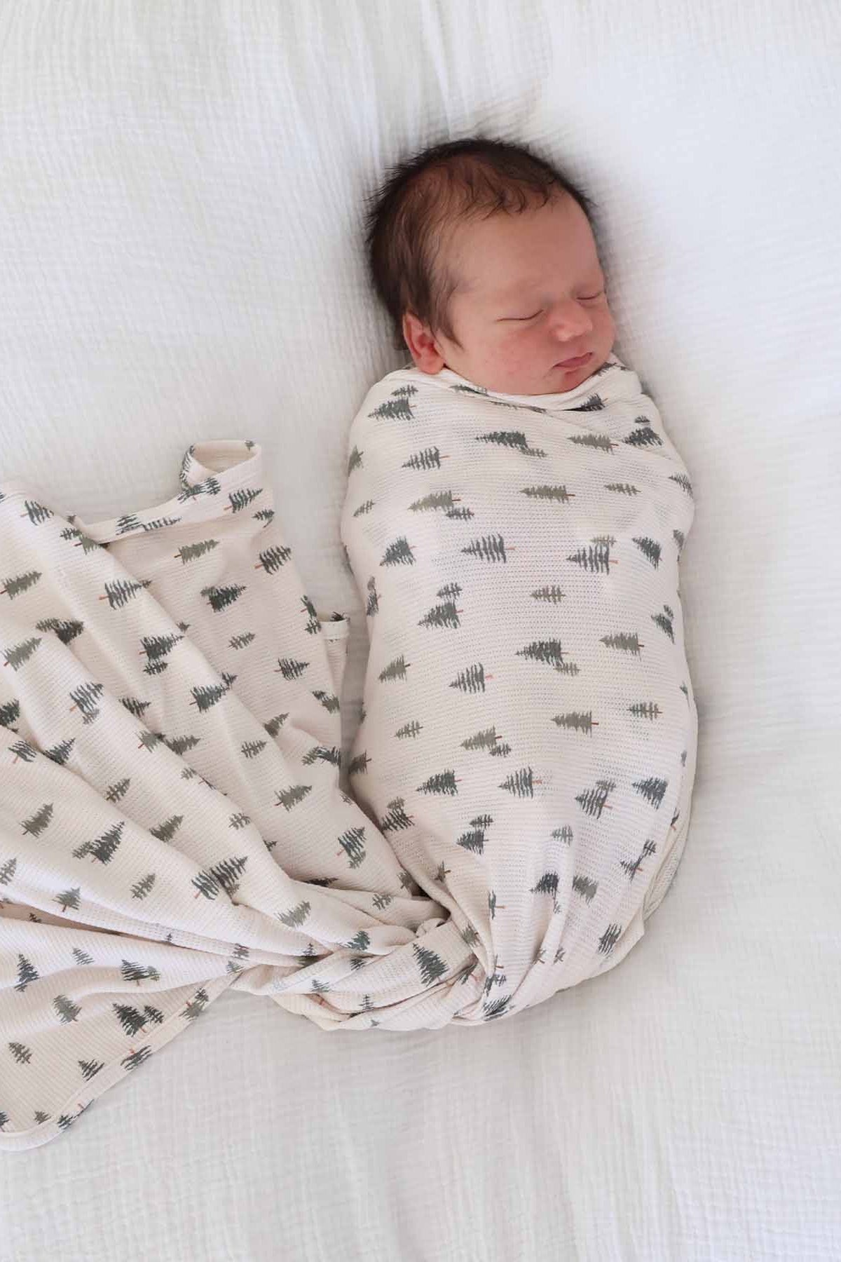 beige bamboo waffle swaddle blanket for newborns with pine trees 