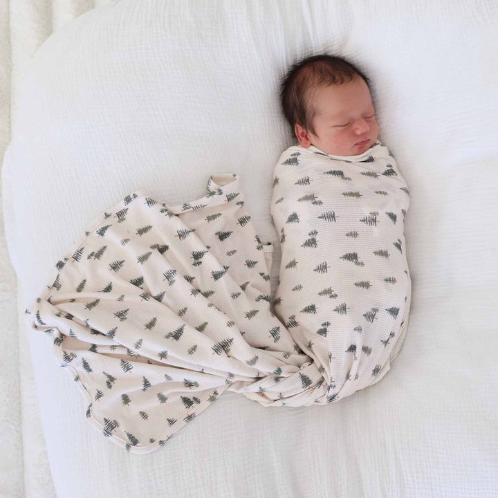 beige bamboo waffle swaddle blanket for newborns with pine trees 