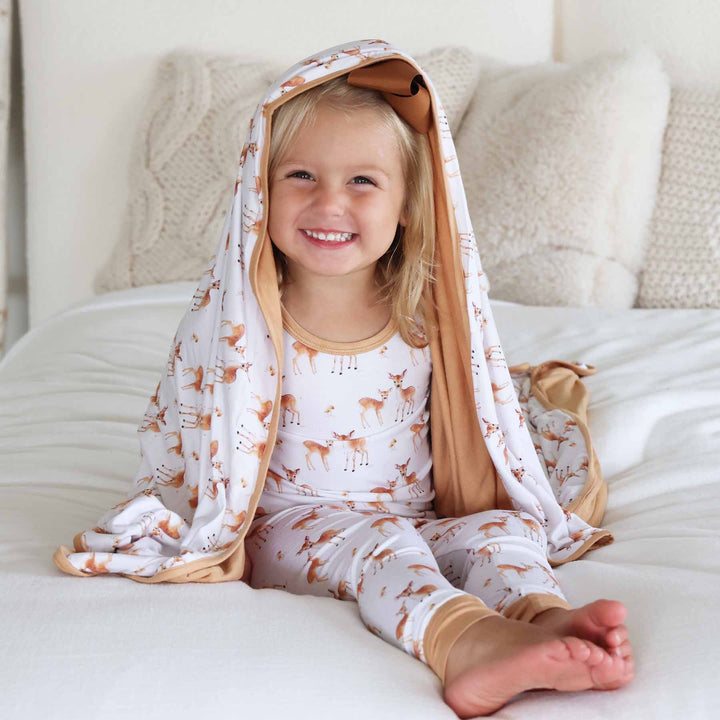 girl wearing fawn long sleeve two piece pajama set with bamboo blanket on top of her head 