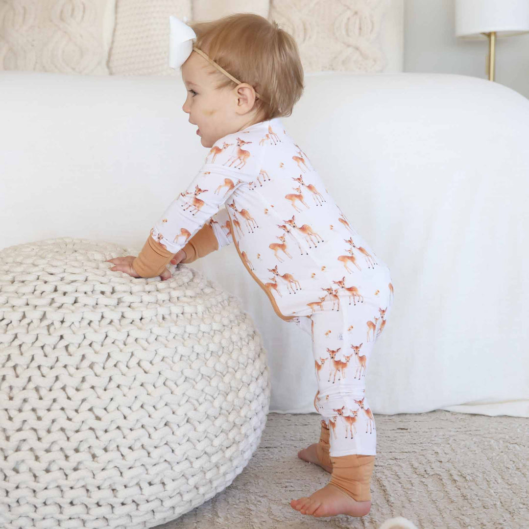 standing toddler wearing fawn zip romper pajama 