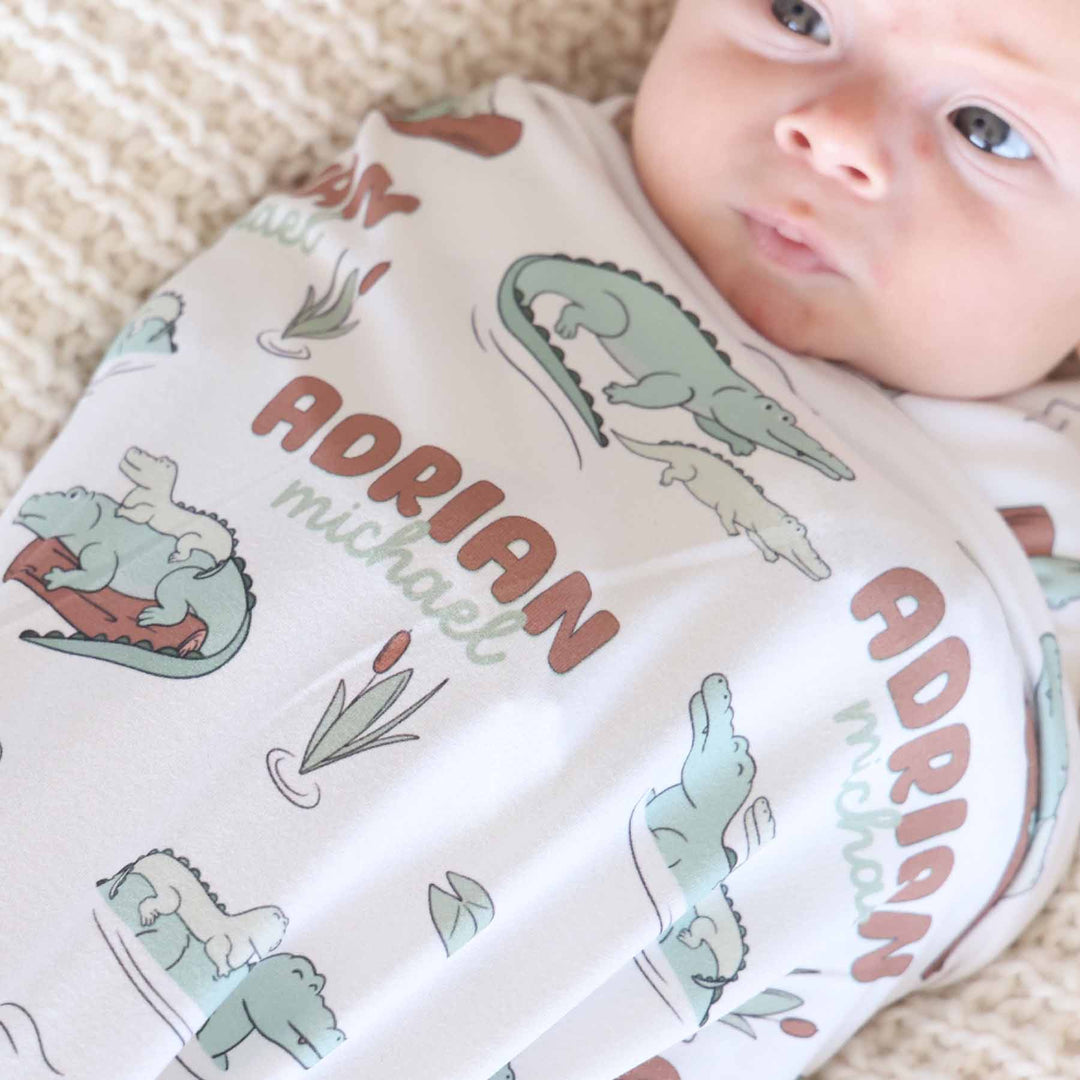 alligator floating on a log personalized baby swaddle blanket 