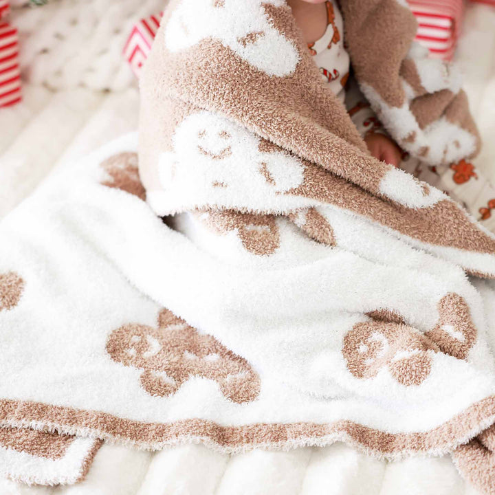microfiber blanket for babies, kids and adults that is white on one side with brown gingerbread man and the reverse side is brown with white gingerbread men.
