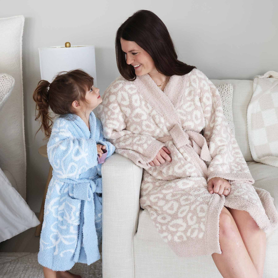 mom wearing a neutral plush robe with girl wearing a light blue and white bowrobe
