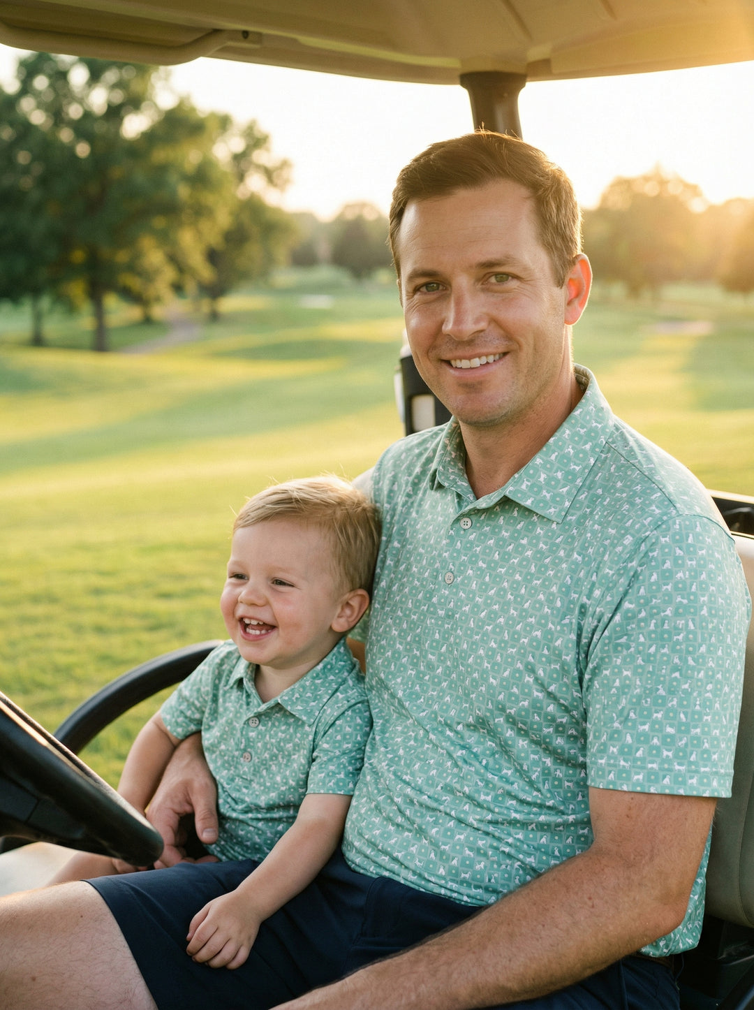 father and son sitting next to each other in golf cart wearing matching dog button up shirts 