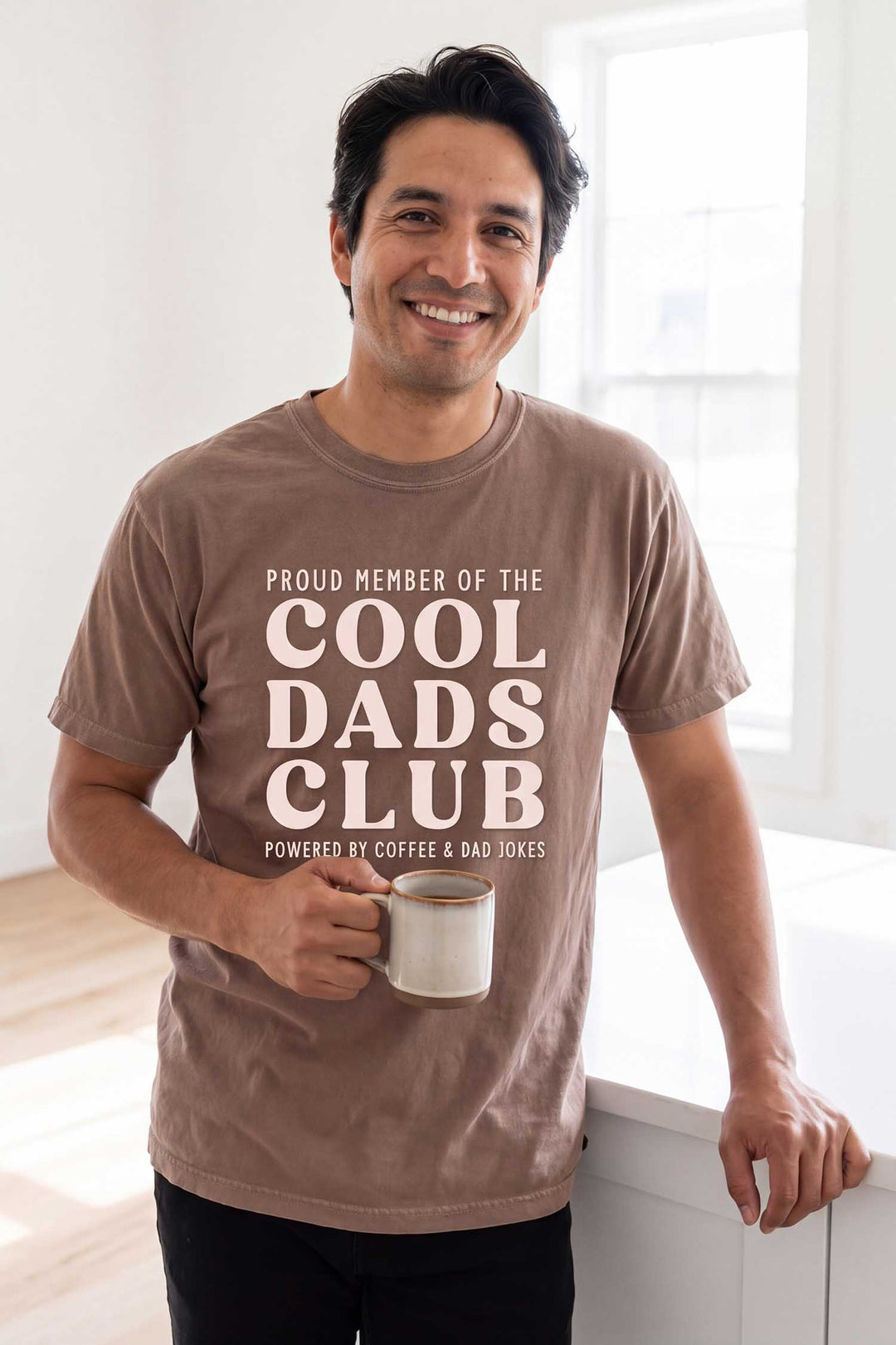 dad holding a coffee mug wearing the proud member of the cool dads club graphic tee