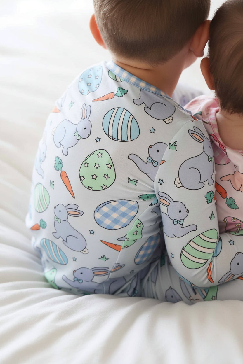 closeup of hoppy spring blue easter two piece pajama print with star and gingham easter eggs, blue bunnies with bow ties and carrots 