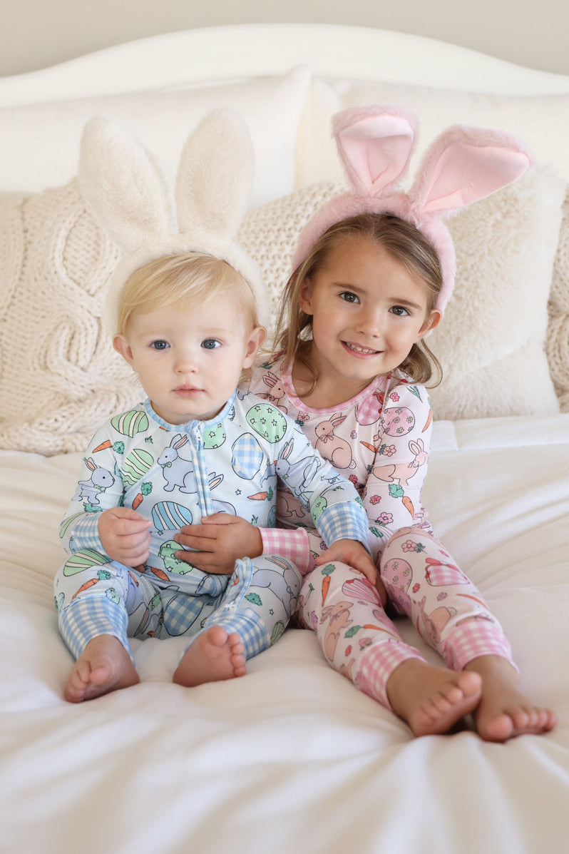 hoppy spring easter sibling matching pajamas in blue and pink with bunnies, easter eggs and carrots with gingham cuffs and trim