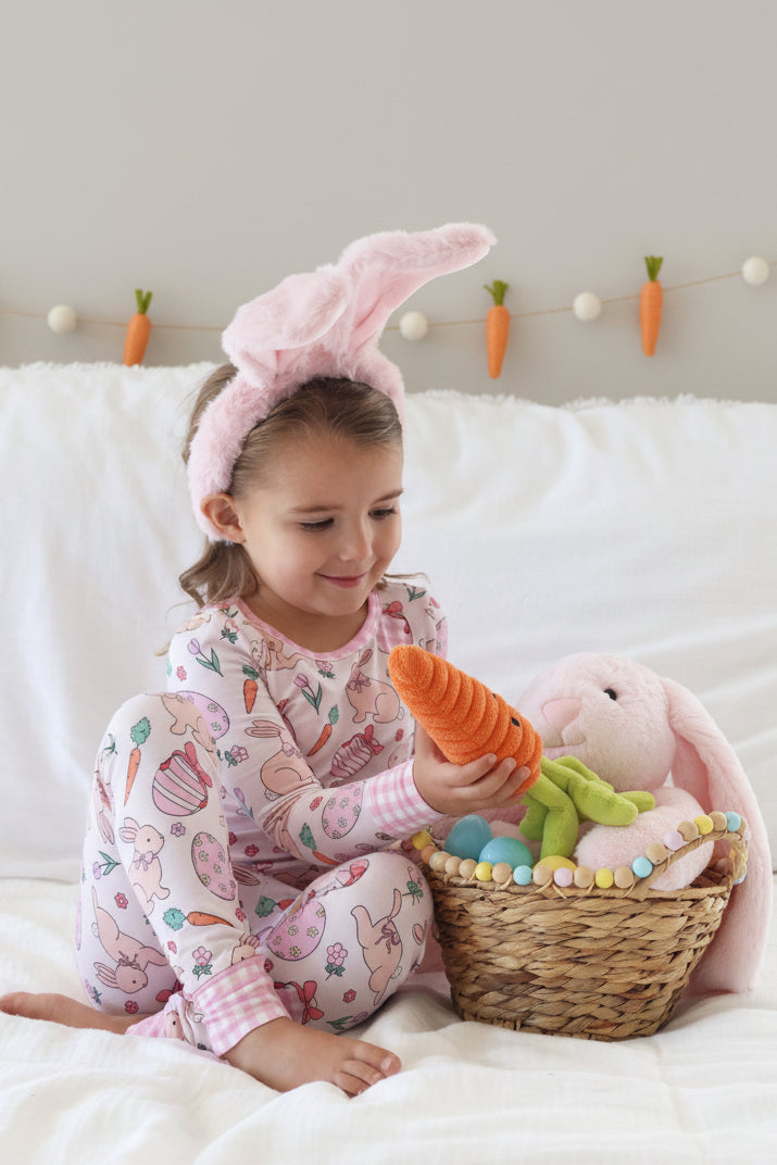 pink easter pajama set for girls with pink bunny ears and a stuffed carrot 