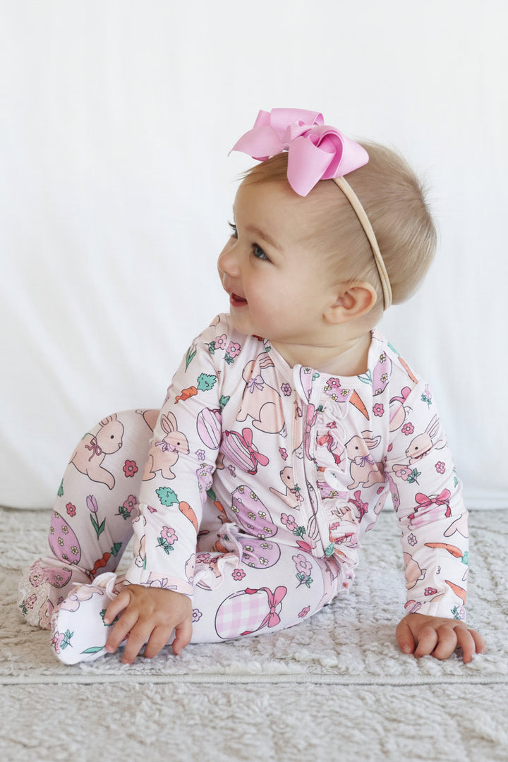 hoppy spring pink ruffle zipper footie pajama for baby girls with a pink ribbon bow headband 