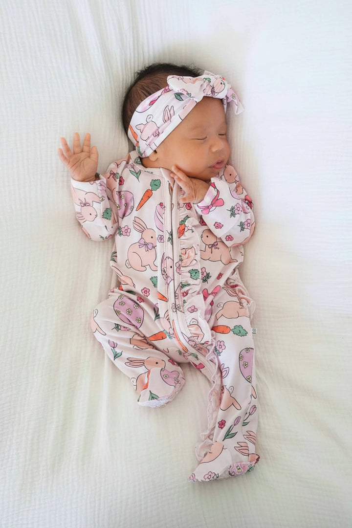 baby wearing the pink hoppy spring ruffle zipper footie and matching headwrap