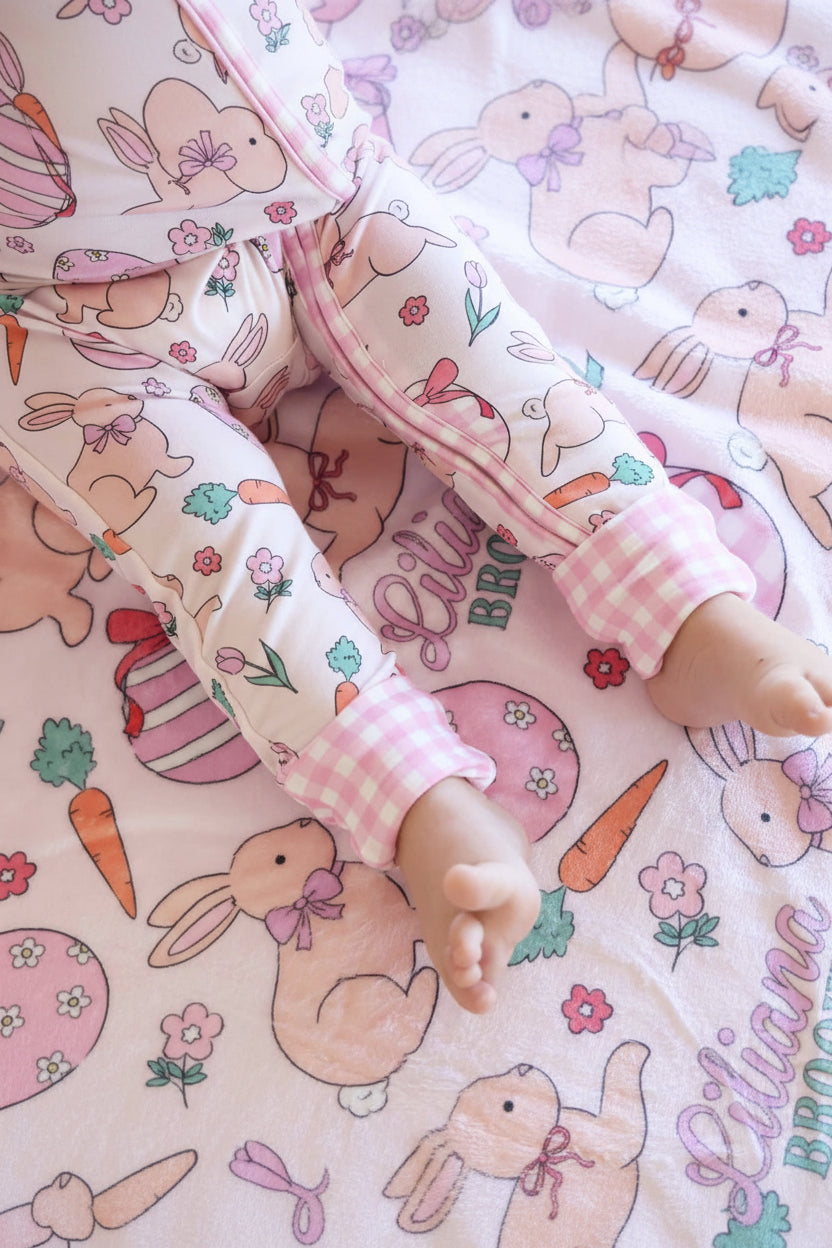 closeup of hoppy spring pink convertible zip romper with gingham cuffs and personalized kids blanket 
