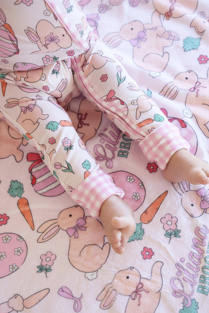 closeup of hoppy spring pink convertible zip romper with gingham cuffs and personalized kids blanket 