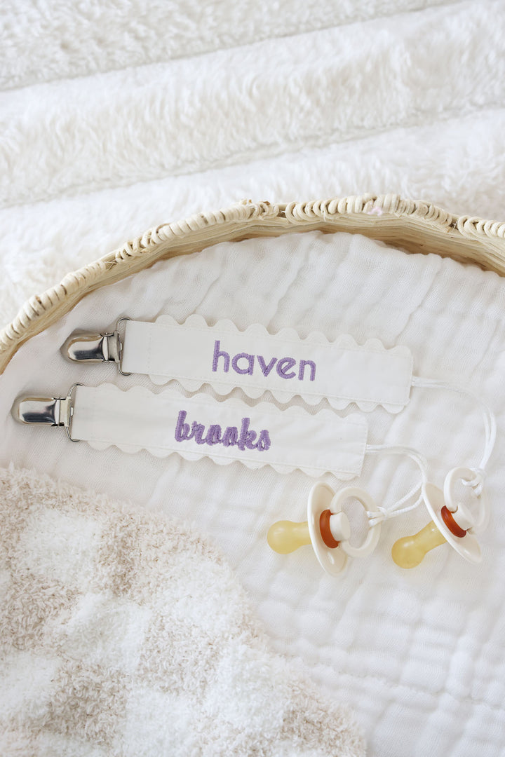 white ric rac pacifier clip with purple font 