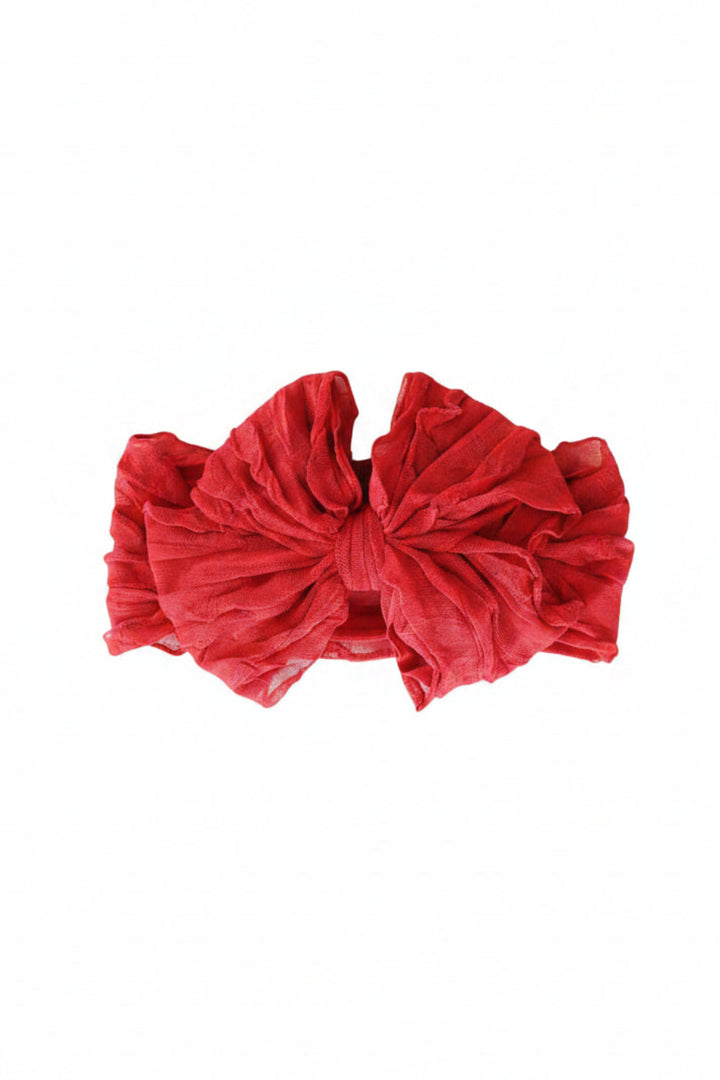 Caden Lane oversized red baby bow headwrap made from soft, stretchy fabric, perfect for Christmas outfits, newborn photos, and holiday celebrations.