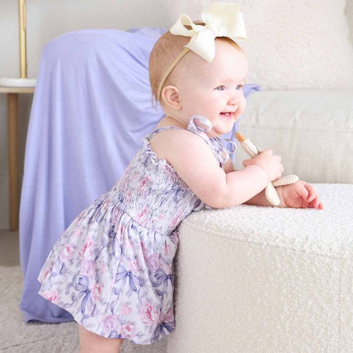 pink and purple bow and floral smocked bodysuit for babies 