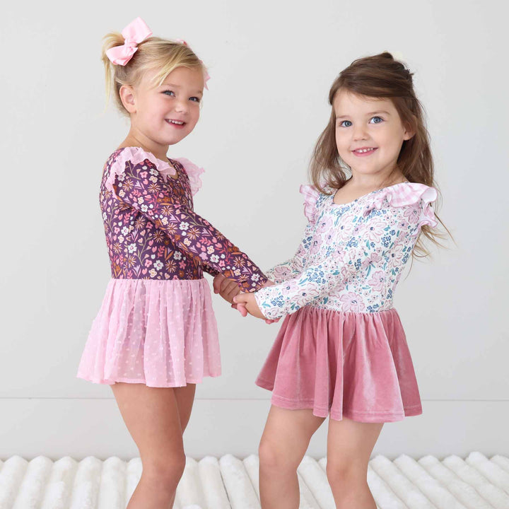two girl wearing long sleeve floral leotards 