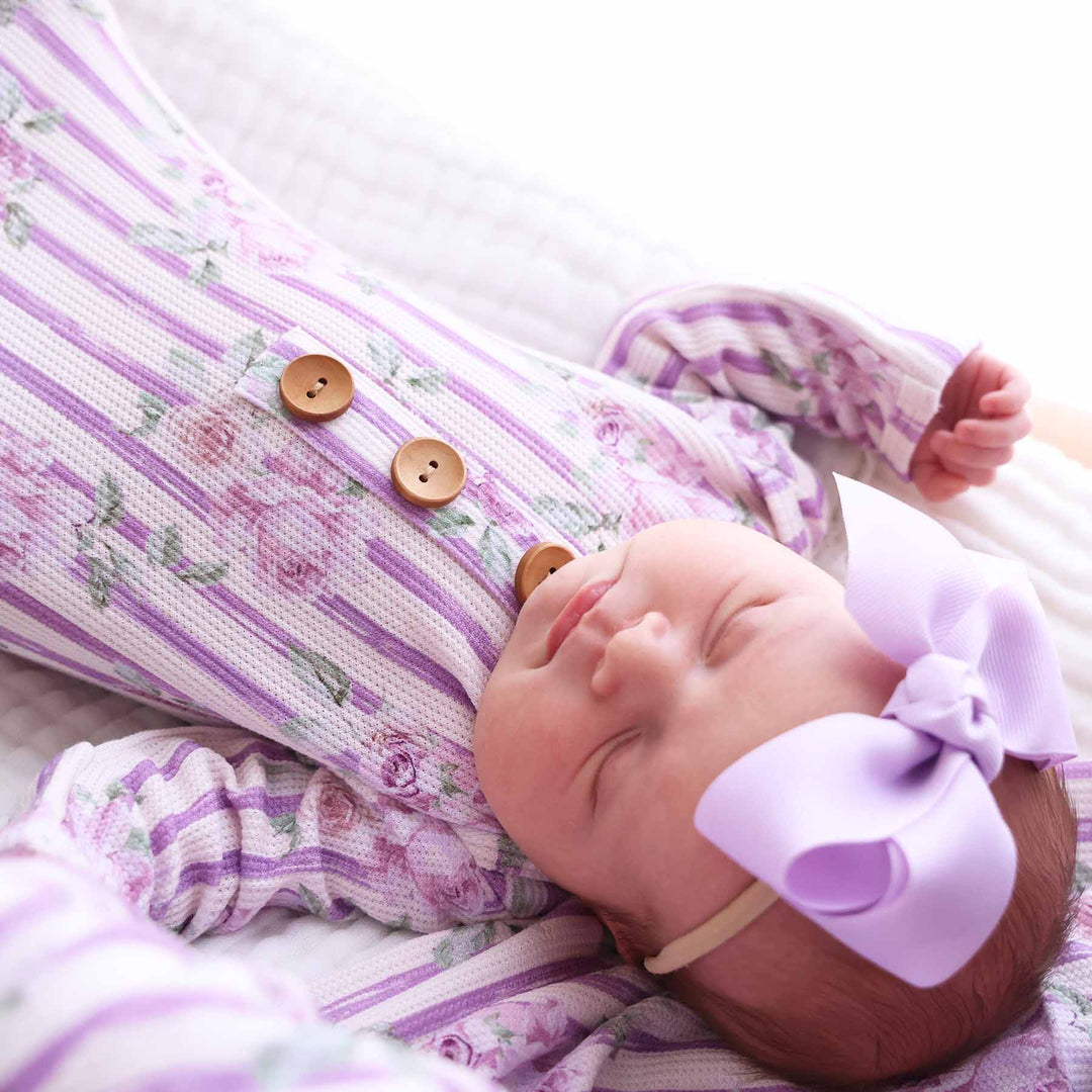 newborn baby girl wearing lila's lilacs bamboo waffle knot gown with lilac ribbon bow headband 