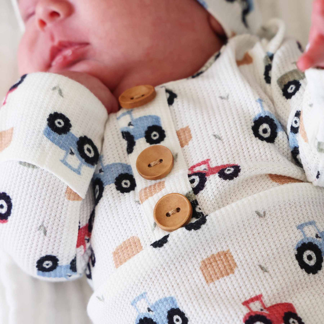 little farmer newborn knot gown with brown wooden buttons and matching hat 