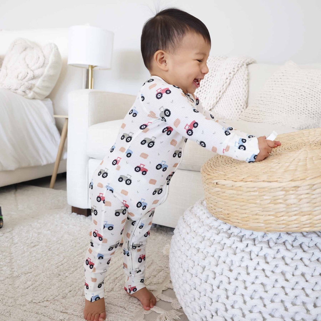 soft white bamboo waffle convertible zip romper pajama with colorful tractors and hay bales 
