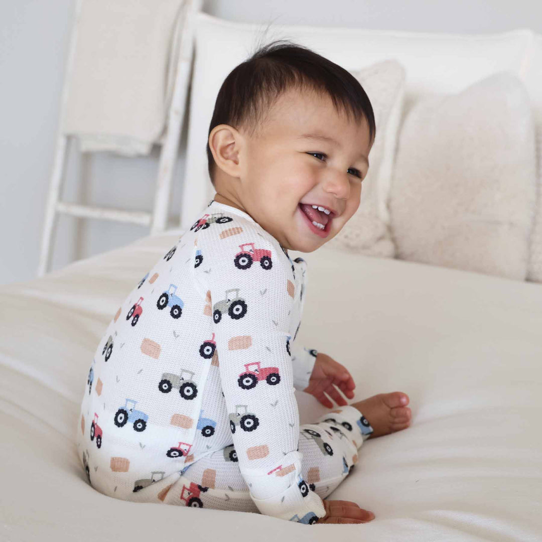 little farmer convertible zip romper pajama for baby and toddler boys with hay bales and greenery sprigs