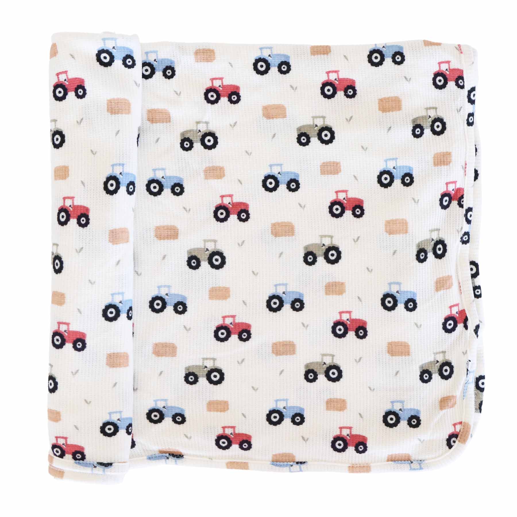 red, green and blue tractor bamboo waffle swaddle blanket with hay bales and greenery