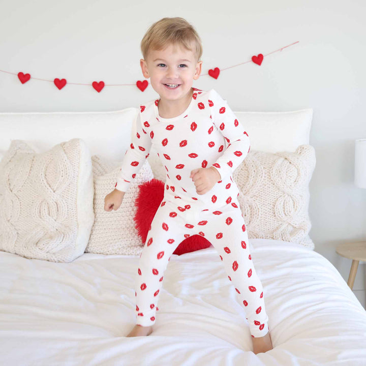 boy standing on bed in long sleeve and pant valentine's day two piece pajama set 