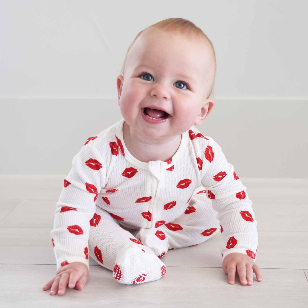 sitting baby boy wearing a red lip valentine's day zipper footie pajama 