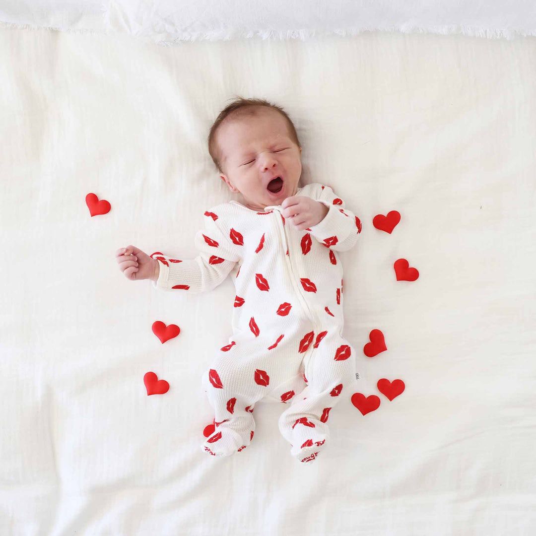 little kisses bamboo waffle zipper footie pajama for babies with heart confetti scattered around him