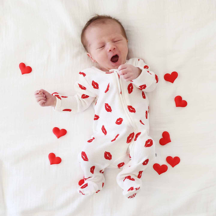 little kisses bamboo waffle zipper footie pajama for babies with heart confetti scattered around him