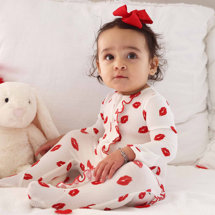 lipstick kisses zipper footie for baby girls with ruffles along the zipper and bottom