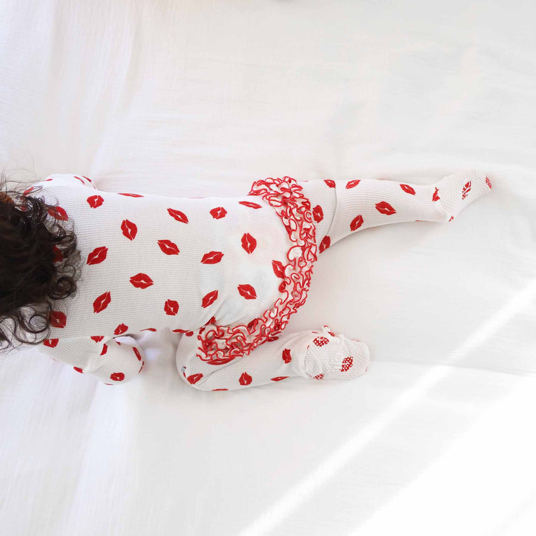 baby girl crawling in a valentine's day kisses bamboo waffle ruffle footie