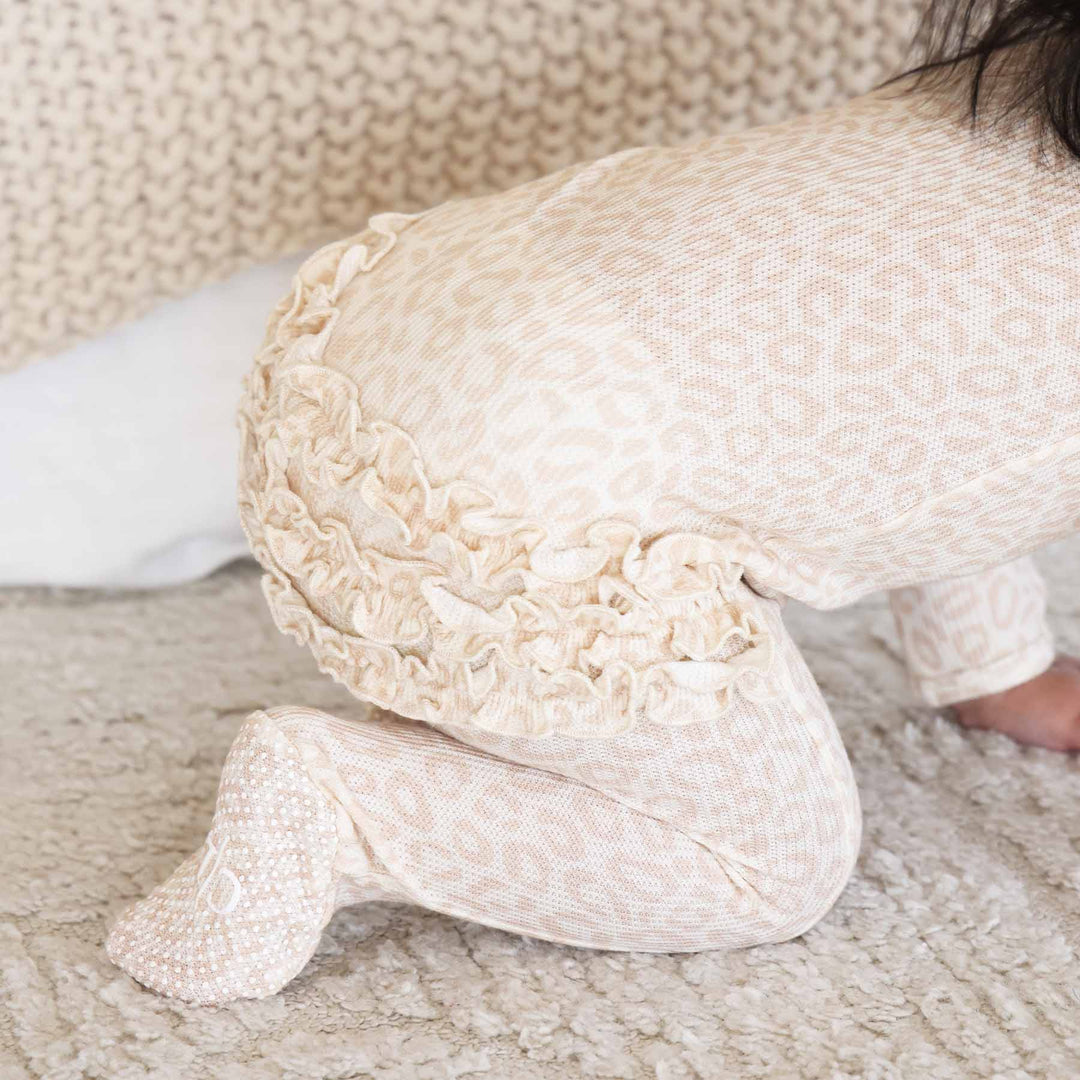 blonde leopard bamboo viscose ruffle footie for girls with a neutral leopard print 