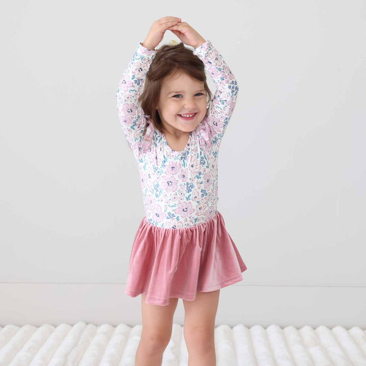 girl wearing a fall floral long sleeve leotard standing like a ballerina 