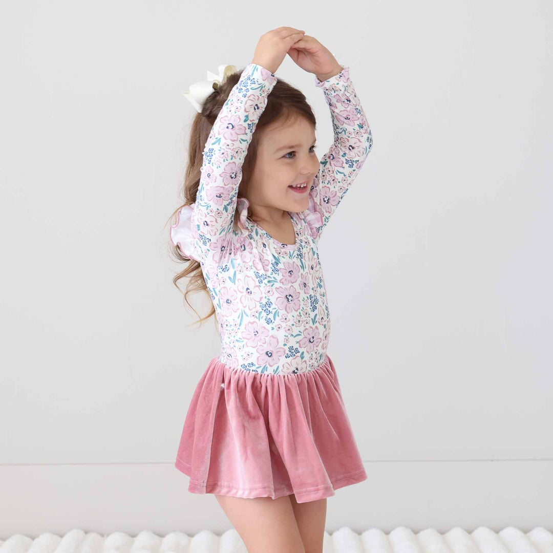 girl wearing a floral and gingham velvet skirt leotard with long sleeves 