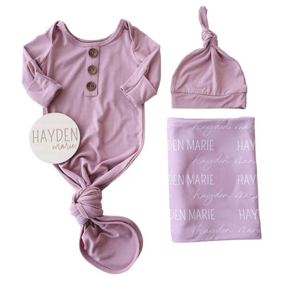 mauve newborn baby bundle with swaddle and wood sign