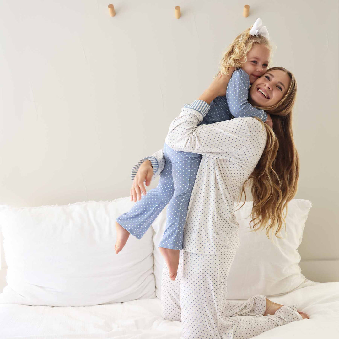 mom and daughter hugging in coordinating polka dot lounge set dusty blue and white polka dots 