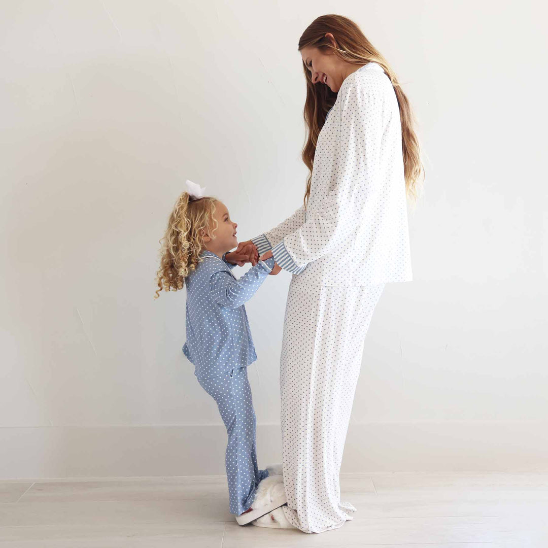 girl standing on her mom's feet wearing a long sleeve flare pants lounge sets with polka dots in inverted colors: dusty blue and white 