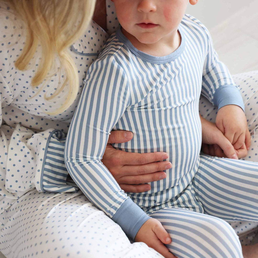 close up of blue and white stripe long sleeve pajama set for boys with a coordinating lounge set for mom with polka dots 