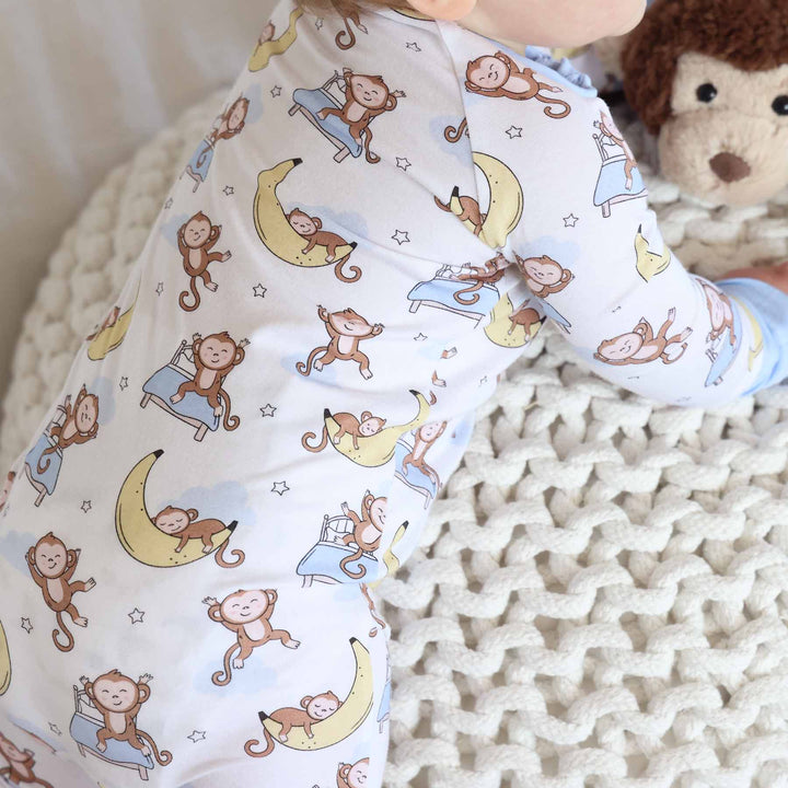 close up of pajamas with monkey sleeping on banana moon and jumping on bed 