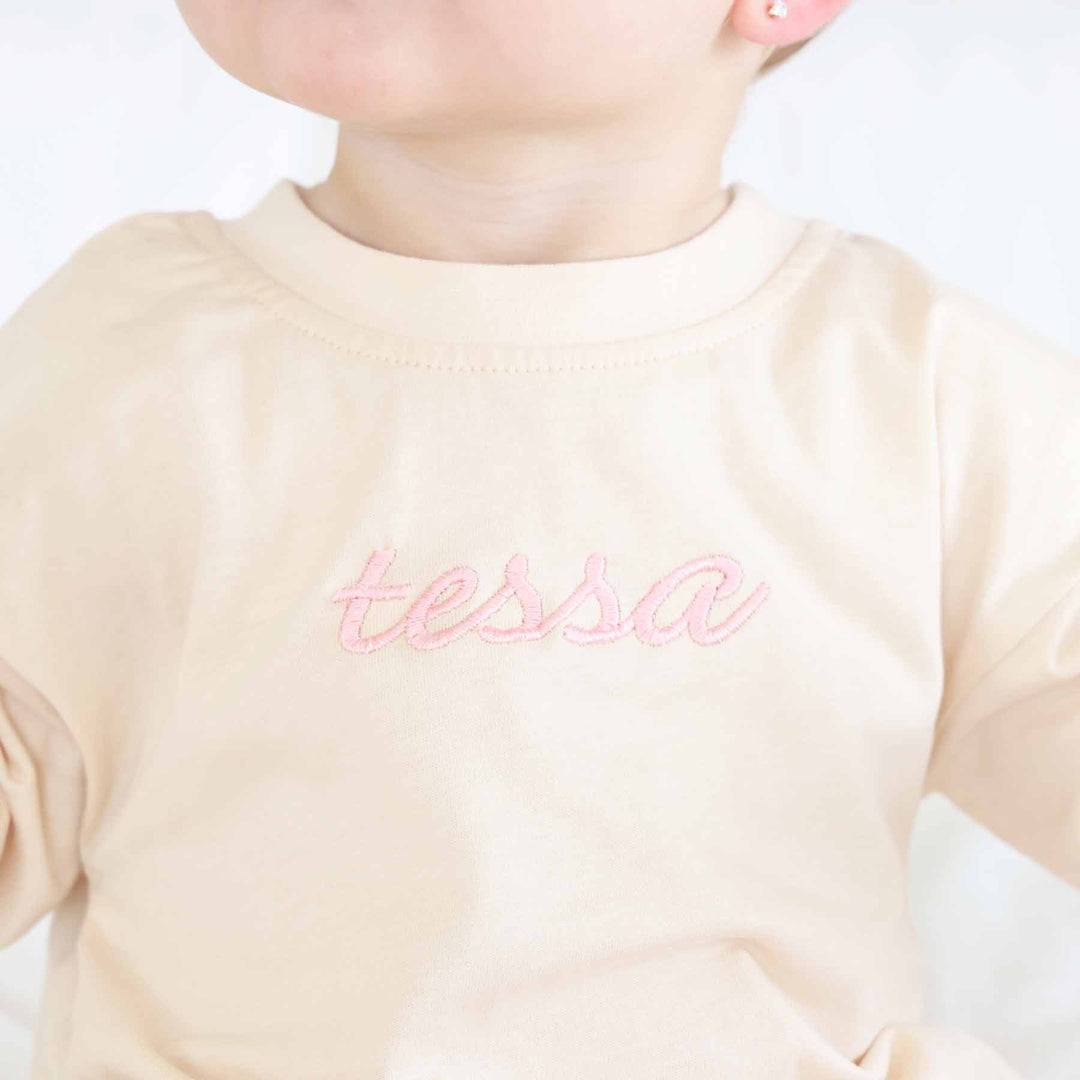 embroidered long sleeve romper for baby girls with light pink thread 