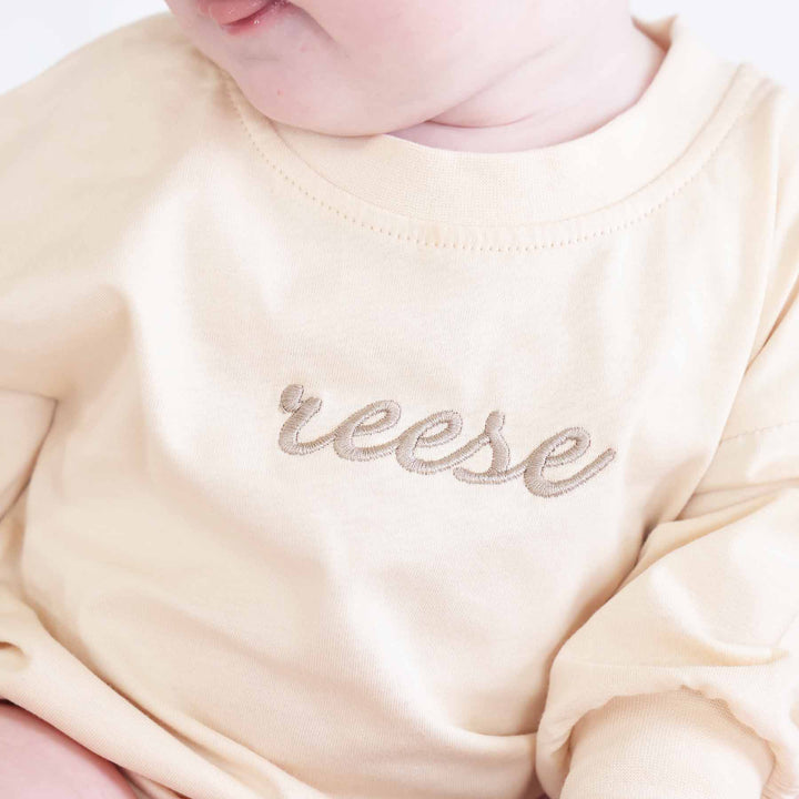 tan thread embroidered name romper for babies with long sleeves 