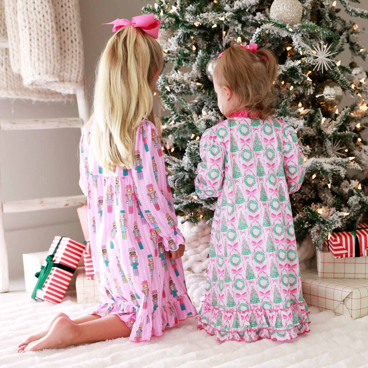 little girls kneeling around the christmas tree with presents in christmas nightgowns 