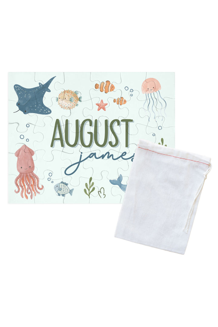 Personalized Caden Lane Ocean Dreams jigsaw puzzle in seafoam, showing sea creatures and custom name, paired with a white drawstring storage bag