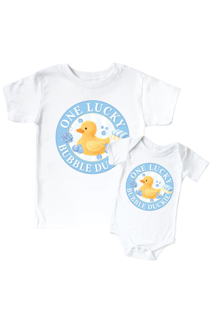 White kids tee and baby bodysuit with blue circle One Lucky Bubble Duckie graphic featuring yellow rubber duck with bubbles