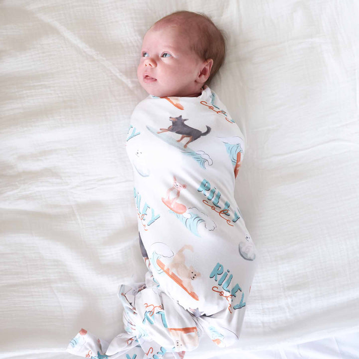 tan personalized swaddle blanket for newborns with surfing dogs 