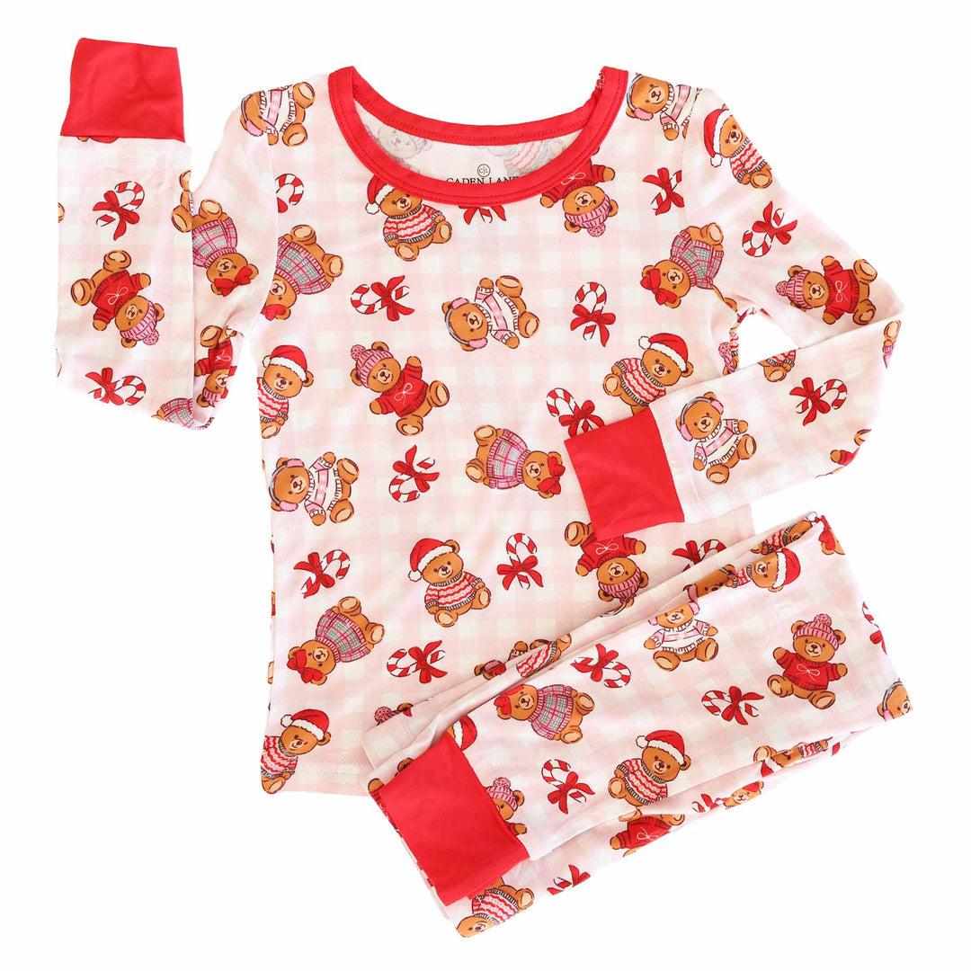 girls pink gingham pajamas with teddy bears dressed in christmas sweaters with santa hats, ear muffs, beanies and bows